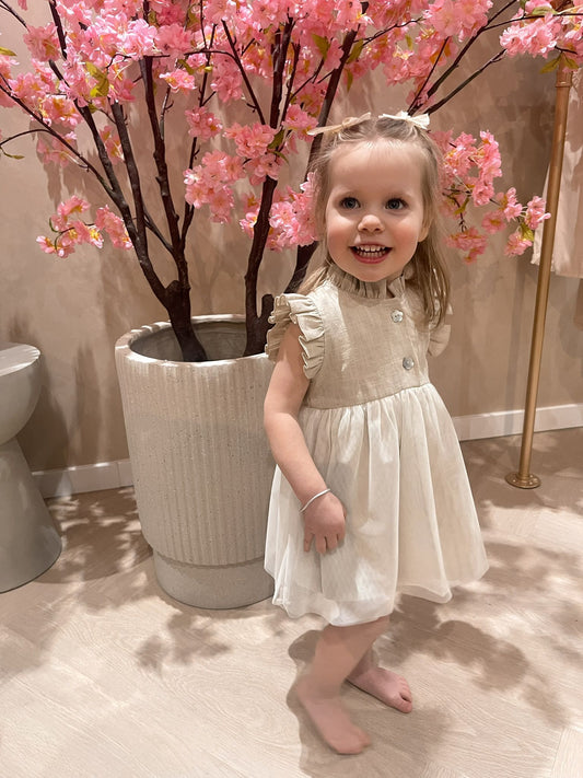 Beige hydrofiel jurkje met knoopjes voorzien van een tule aangenaaid rokje voor kinderen