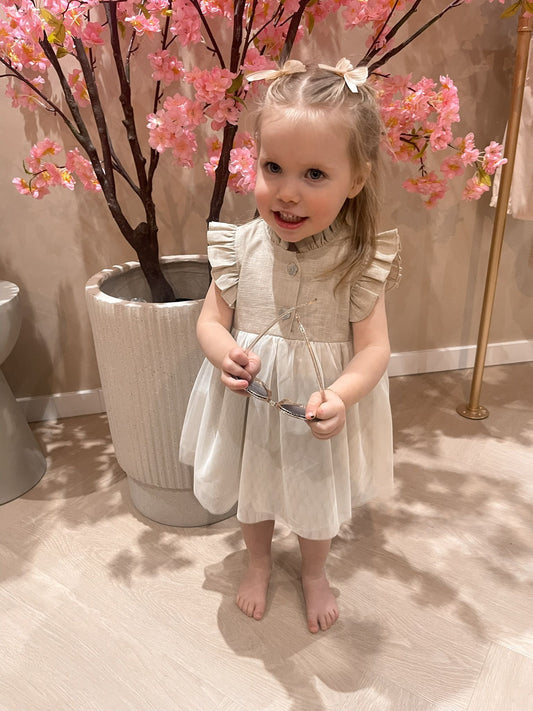 Beige hydrofiel jurkje met knoopjes voorzien van een tule aangenaaid rokje voor kinderen